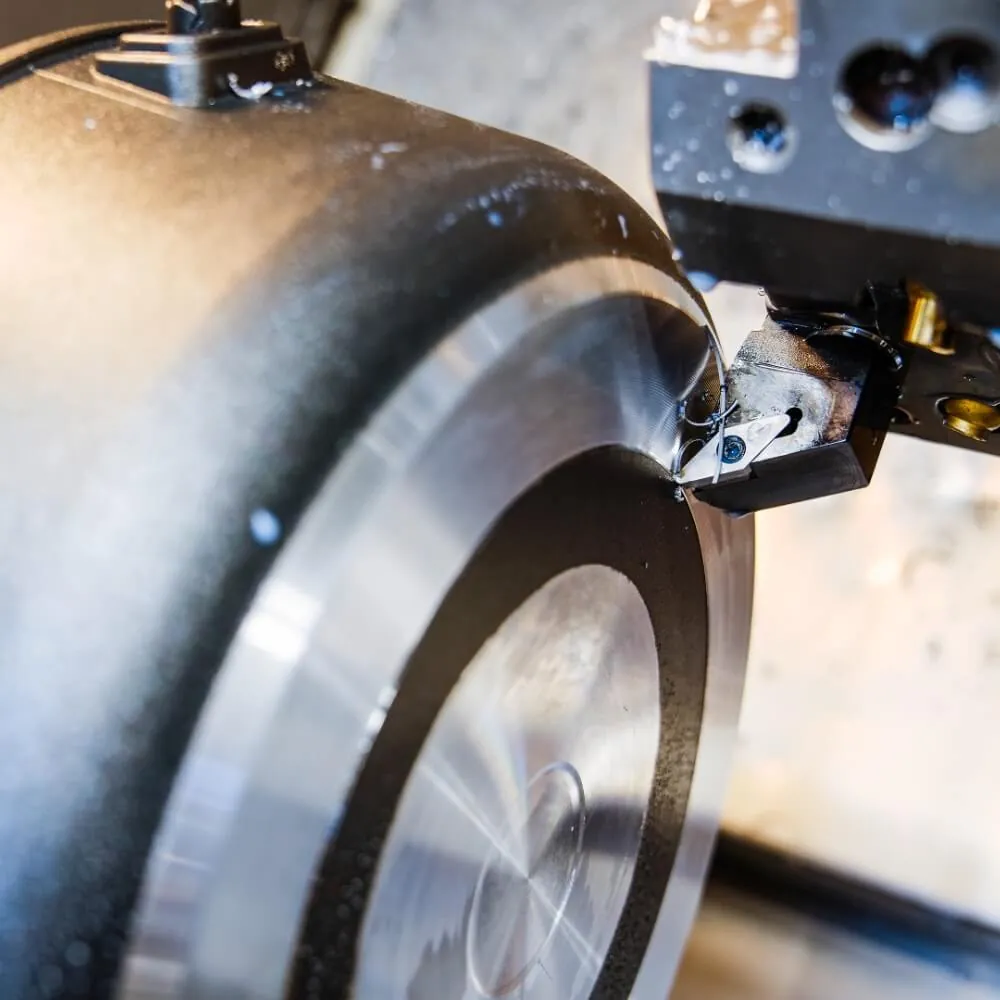 A cast pan body being turned flat on a lathe